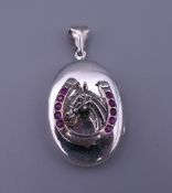 A silver and stone set horseshoe locket. 2.5 cm wide.