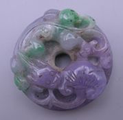 A multi-coloured jade carved disc. 5 cm diameter.