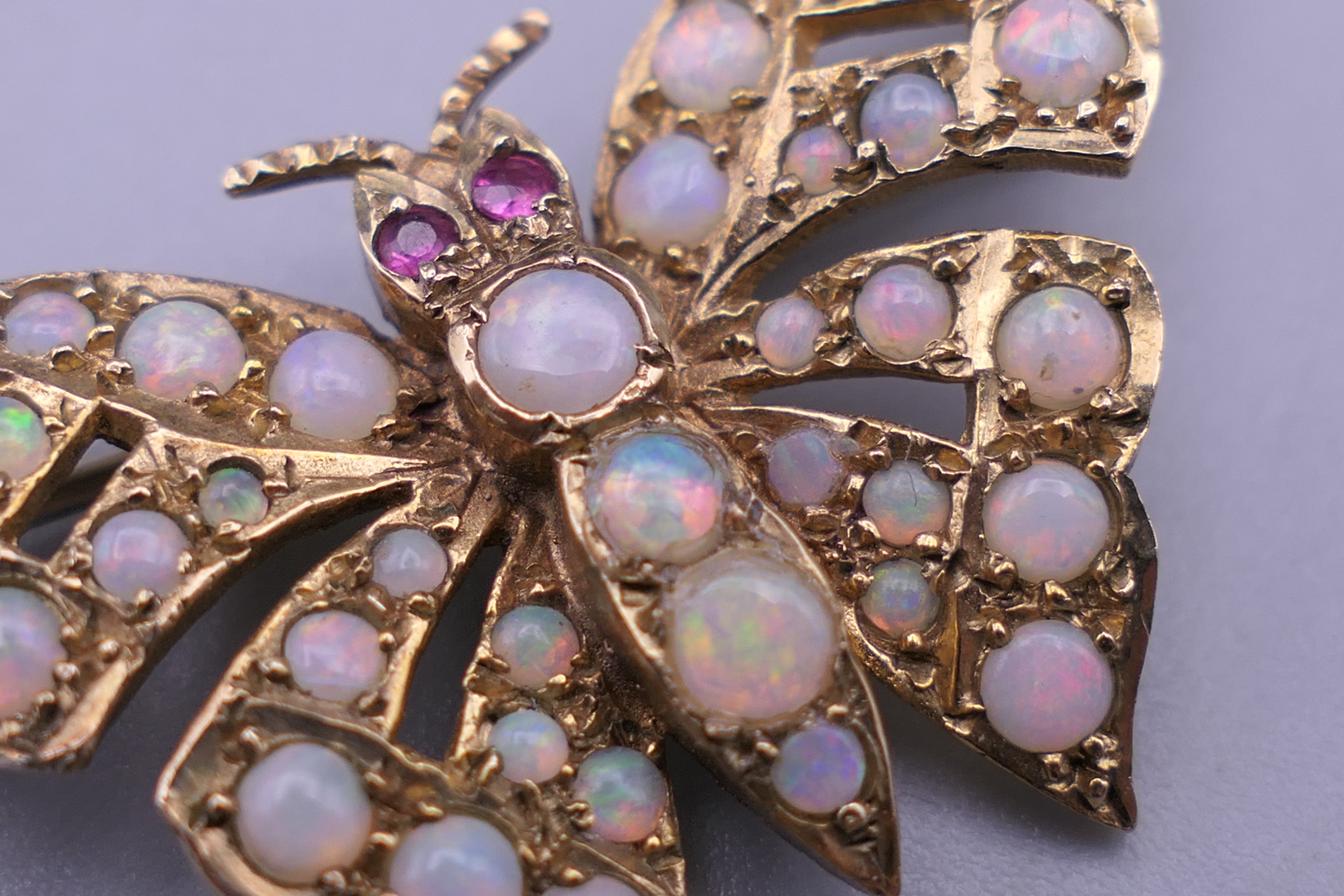 A 9 ct gold opal and ruby set butterfly brooch. 4 cm wide. 6 grammes total weight. - Image 6 of 10