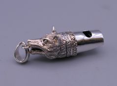 A silver whistle formed as a fox's head. 4 cm long.