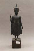 An Oriental bronze model of Buddha mounted on a later wooden plinth base. 42.5 cm high.