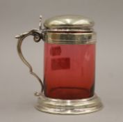 A cranberry glass and silver plated tankard. 14 cm high.