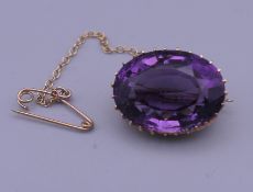 An 18 ct gold and amethyst brooch. 2 cm wide. 5.9 grammes total weight.