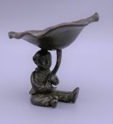 A bronze model of a boy and a lily pad. 7 cm high.