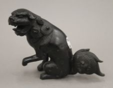 A patinated bronze model of a dog of fo. 11.5 cm high.