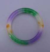 A multi-coloured jade bangle. 7.5 cm exterior diameter.