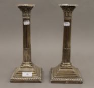 A pair of silver Corinthian column candlesticks. Each 29.5 cm high.