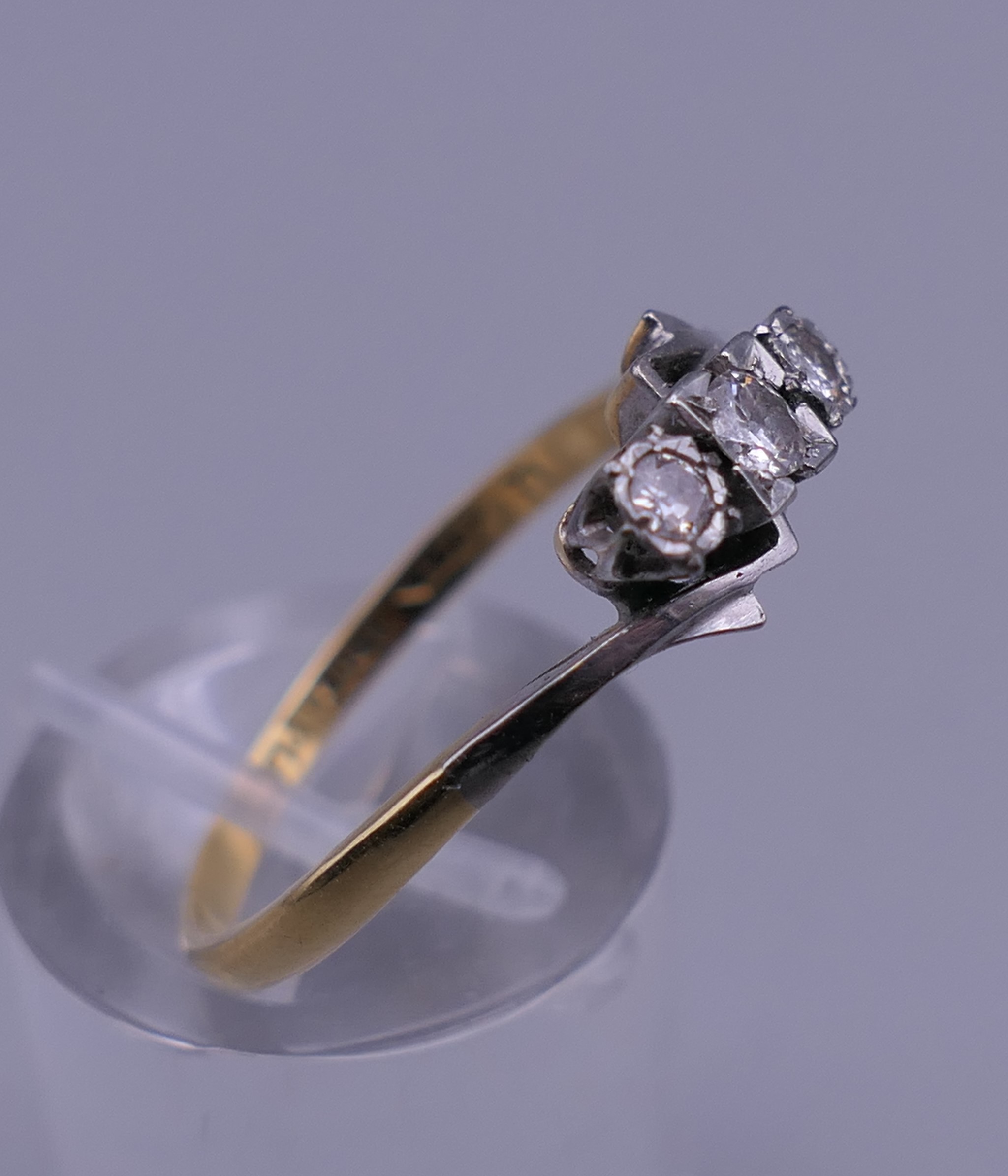 An 18 ct gold and platinum three stone diamond ring. Ring size R/S. 2.6 grammes total weight. - Image 2 of 6