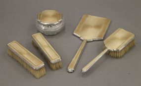 A silver and enamel dressing table set.