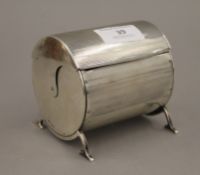 A cylindrical silver cigarette box. 9 cm wide. 10.1 troy ounces total weight.