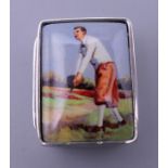 A silver pill box depicting a golfer. 3 cm high.