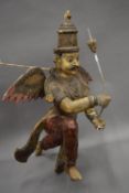 A large polychrome painted Indian carved wooden model of a deity. Approximately 89 cm high.
