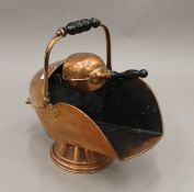 A Victorian copper coal scuttle and a shovel.