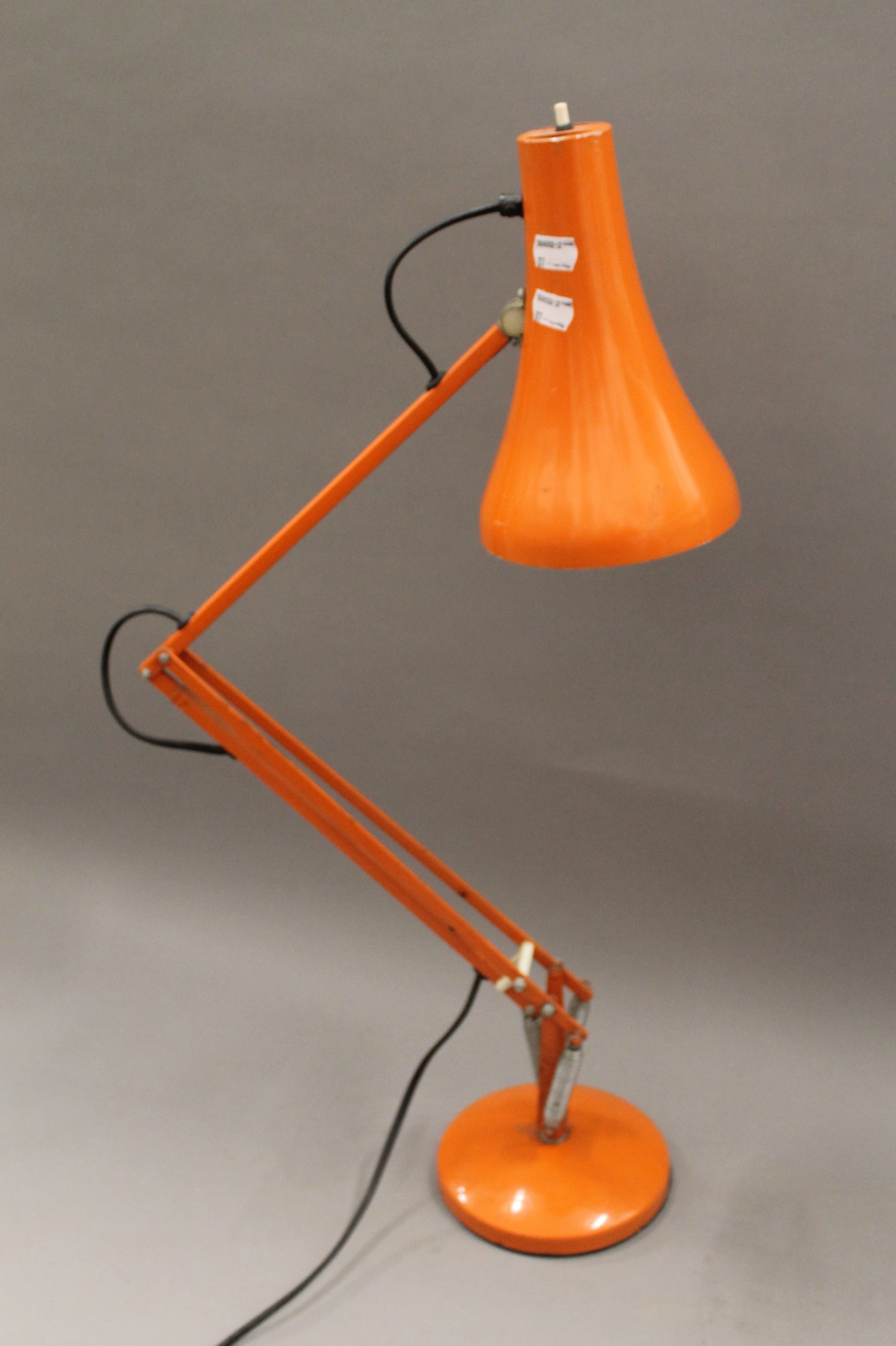 An orange angle poise lamp.