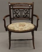 An Edwardian inlaid walnut open armchair. 61 cm wide.