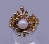 A Contemporary 14 K gold and pearl ring. Ring size N/O. 7.8 grammes total weight.