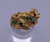 A Contemporary 18 ct gold and emerald ring. Ring size F/G. 11.9 grammes total weight.