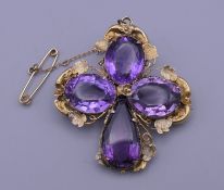 A 19th century unmarked gold and amethyst quatrefoil pendant/brooch. 4 cm high. 7.