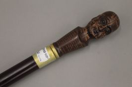 A walking stick with a phrenology head handle. 92 cm long.