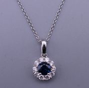 An 18 ct white gold sapphire and diamond pendant and chain. The pendant 2.75 cm wide. 3.