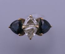 An 18 K gold diamond and sapphire ring. Ring size K. 3.3 grammes total weight.