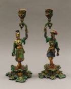 A pair of brass chinoiserie figural candlesticks. Each 27.5 cm high.