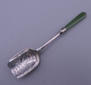 A silver caddy spoon with jade handle. 10 cm long. 8.6 grammes total weight.