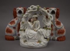 A pair of Victorian Staffordshire spaniels and a Staffordshire figural group. The former each 21.