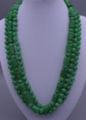 A string of jade beads on a gold clasp. Approximately 150 cm long.