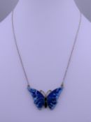 An enamel and silver butterfly pendant on chain. The pendant 3.75 cm wide.