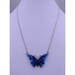 An enamel and silver butterfly pendant on chain. The pendant 3.75 cm wide.