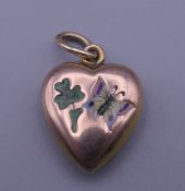 An Edwardian 9 ct gold heart shaped pendant set with enamel butterfly and clover. 1.5 cm high.