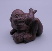 A carved wooden netsuke formed as a man and a rat. 5 cm high.