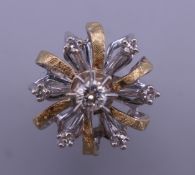 An 18 ct yellow and white gold diamond cluster ring. Ring size E/F. 6.5 grammes total weight.