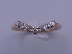 A 9 ct gold 1/4 ct diamond wish bone ring. Ring size N. 1.9 grammes total weight.