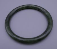 A jade bangle. 8 cm diameter exterior.