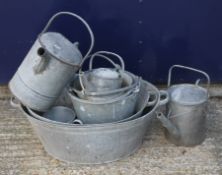 A quantity of galvanized watering cans and buckets.