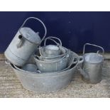 A quantity of galvanized watering cans and buckets.