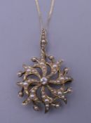 An Edwardian 15 ct gold pearl and diamond pendant on an 18 ct gold chain. The pendant 2.75 cm wide.