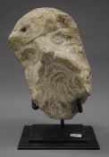 An interesting carved stone head mounted on a metal display stand. 21 cm high overall.