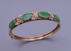 A gold jade and diamond bangle form bracelet. 5.5 cm wide. 11.9 grammes total weight.