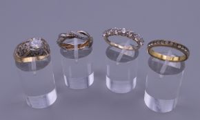 A 9 ct gold seven stone ring and three yellow metal rings. 12 grammes total weight.