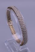 A 9 ct gold tennis bracelet. 19 cm long. 18.1 grammes total weight.