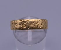 A 22 ct gold embossed wedding band. Ring size Q/R. 3.2 grammes.