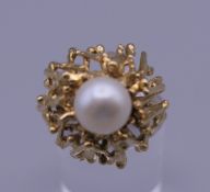 A Contemporary unmarked gold and pearl ring. Ring size L. 10.3 grammes total weight.