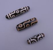 Three agate dzi beads. The largest 5.75 cm long.