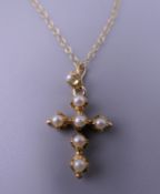 An 18 ct gold pearl crucifix on a 9 ct gold chain. 4.3 grammes total weight.