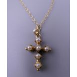 An 18 ct gold pearl crucifix on a 9 ct gold chain. 4.3 grammes total weight.