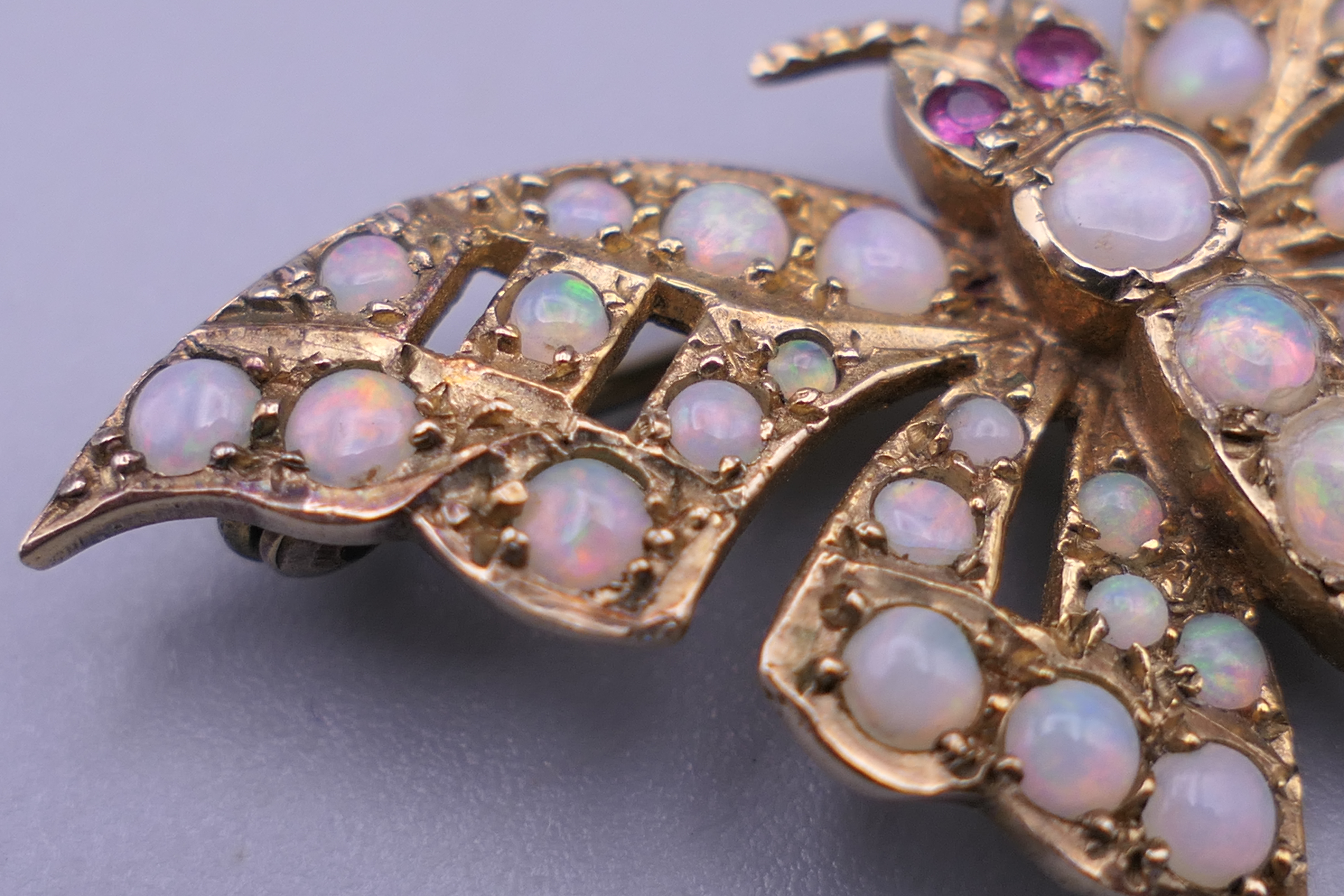 A 9 ct gold opal and ruby set butterfly brooch. 4 cm wide. 6 grammes total weight. - Image 5 of 10