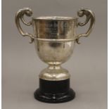 A silver twin handled trophy cup on a plinth base. 25 cm high overall. 14.